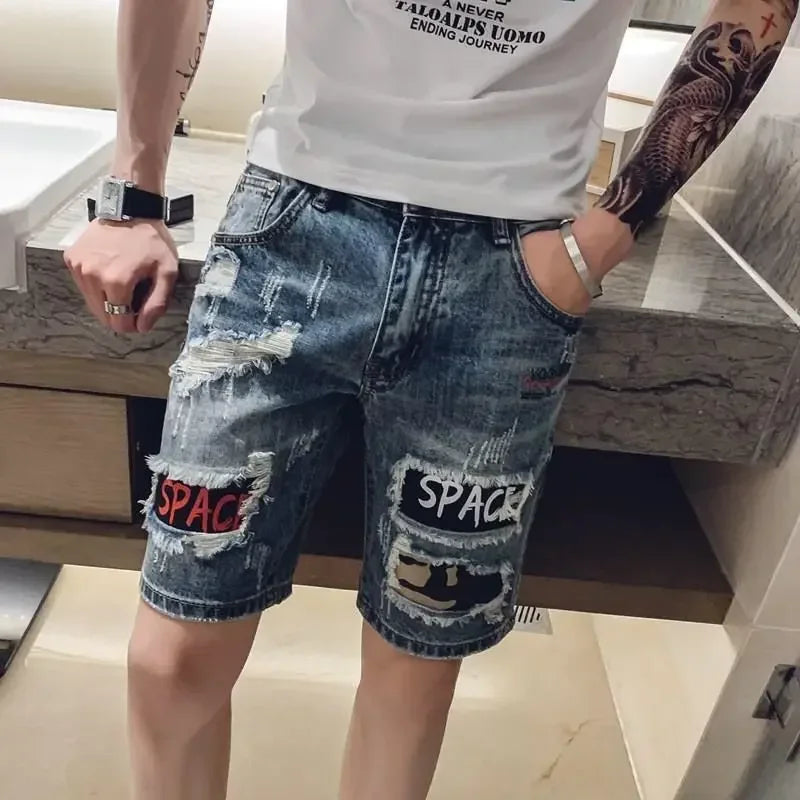 Person wearing ripped denim shorts with 'SPACE' patches in an indoor setting.