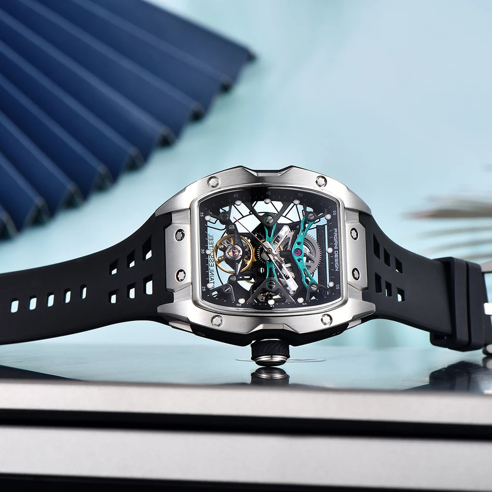 Luxury watch with black strap and silver case on a reflective surface