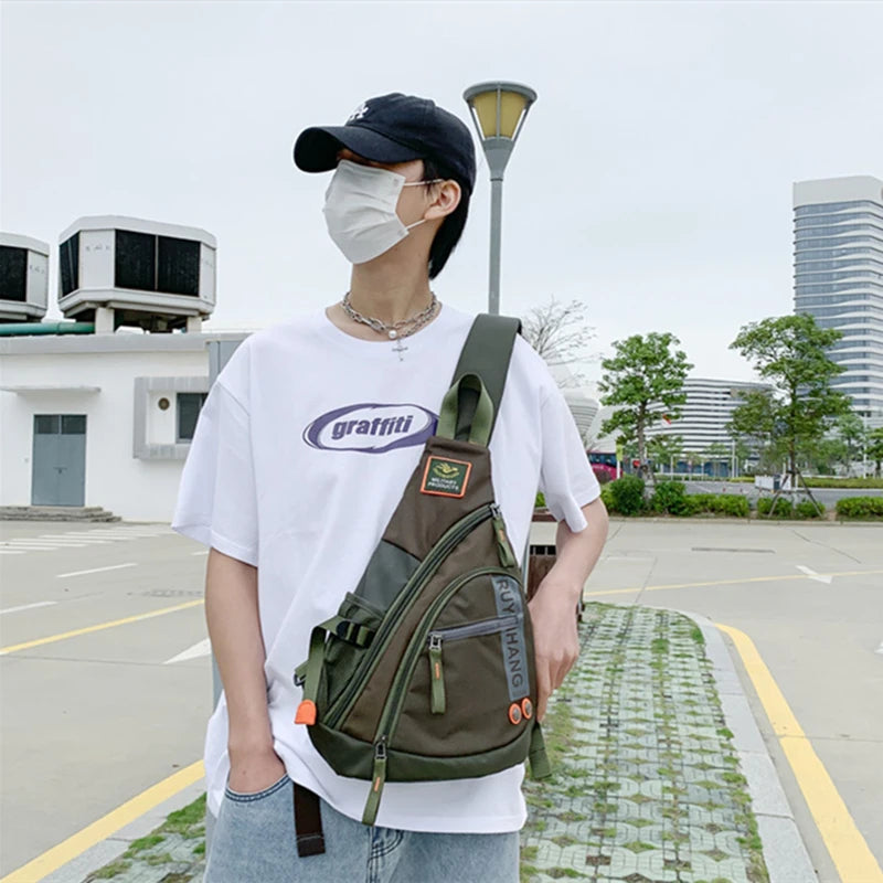 Person wearing a white t-shirt with a logo, light blue jeans, and a green backpack in an outdoor setting.