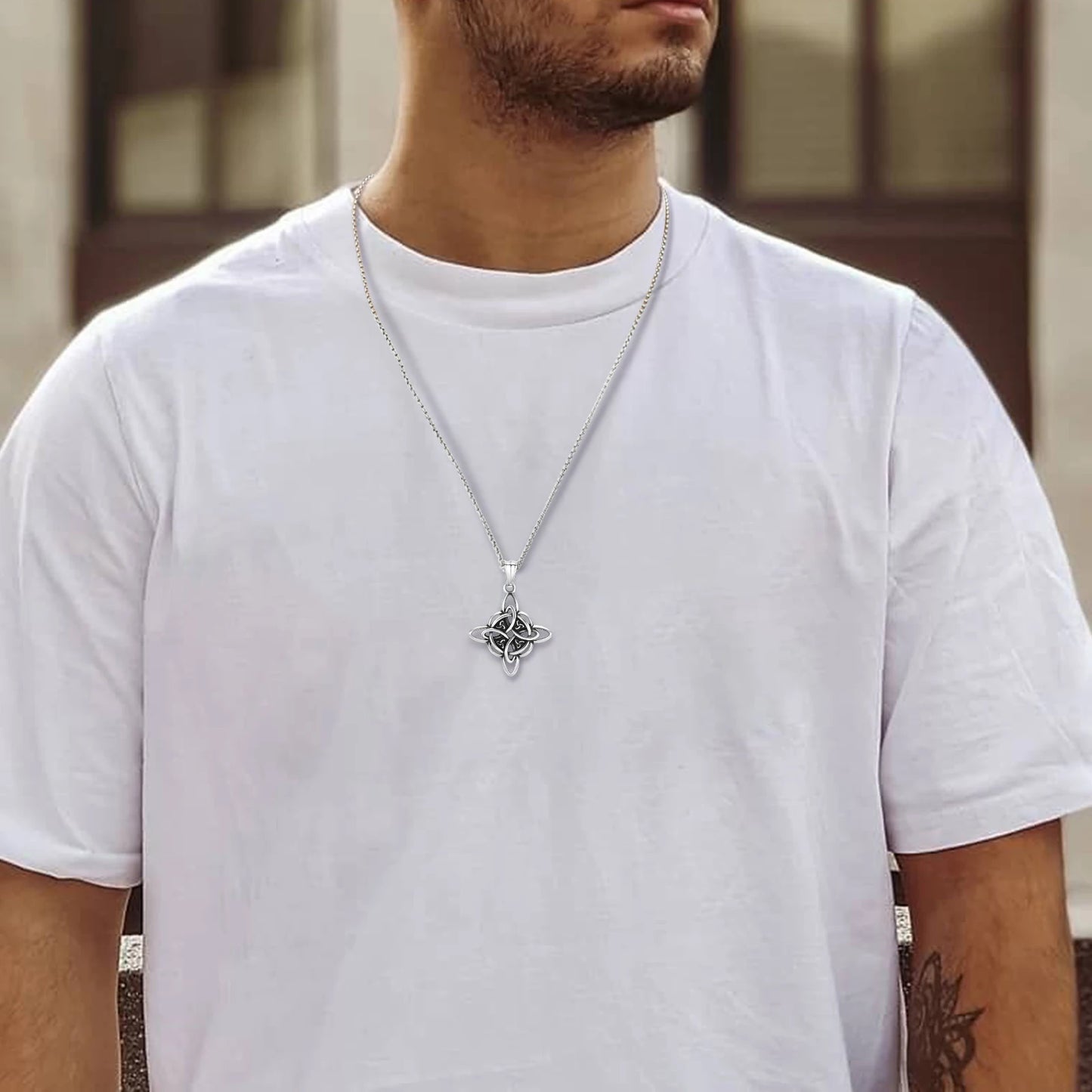Man wearing a Vnox stainless steel Celtic Knot amulet necklace with a silver Triquetra pendant on a white t-shirt.