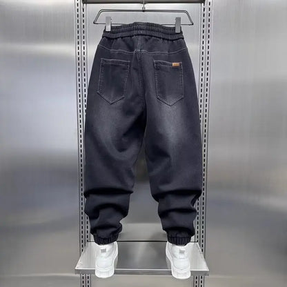 Black baggy jeans on a metal rack with a neutral background