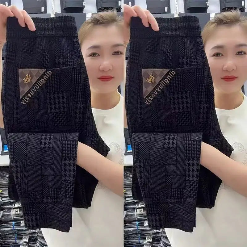 Person holding black patterned socks with a brand logo, wearing a white shirt.