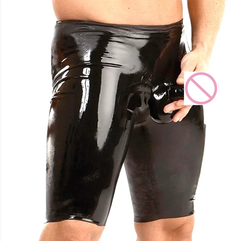 Person wearing black shiny shorts holding a no symbol card on a white background