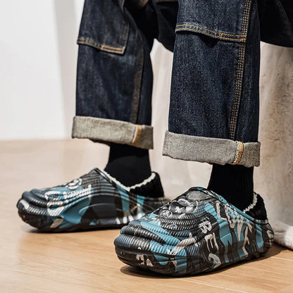 Person wearing patterned slip-on shoes with rolled-up jeans on a light wooden floor.