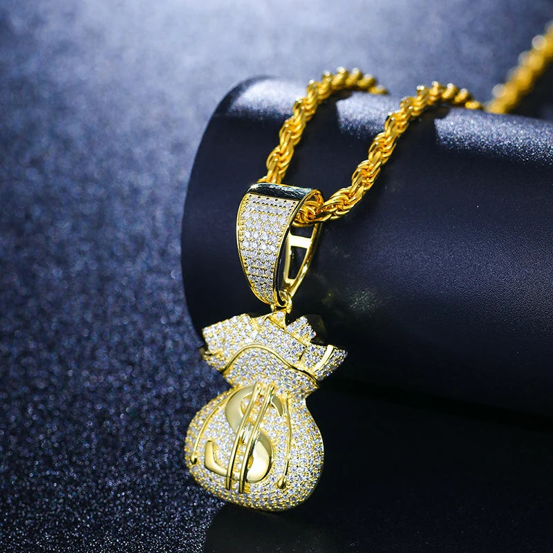 Gold pendant shaped like a money bag on a dark background