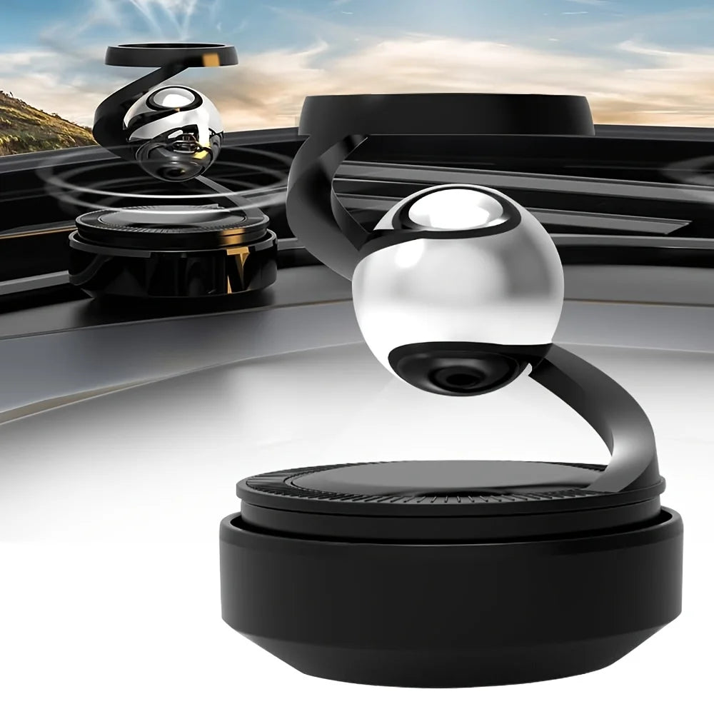 Car air freshener with a metallic ball design on a car dashboard