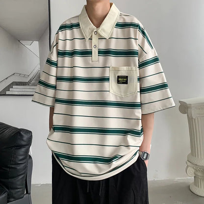 Person wearing a striped polo shirt with a pocket in an indoor setting
