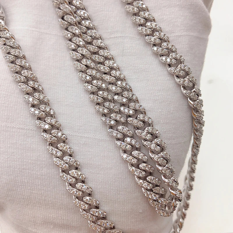 Silver chain necklace on a white fabric background