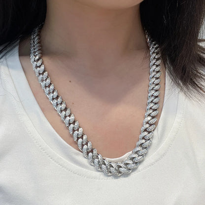 Silver chain necklace worn by a person on a white background